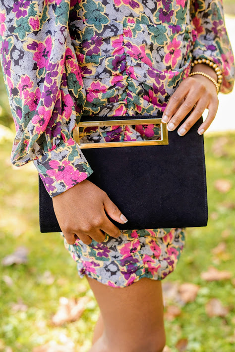 model holding black suede clutch by Lisi Lerch