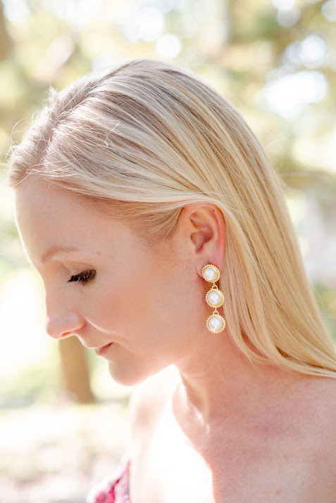 model wearing gold dangle earrings with three large pearls
