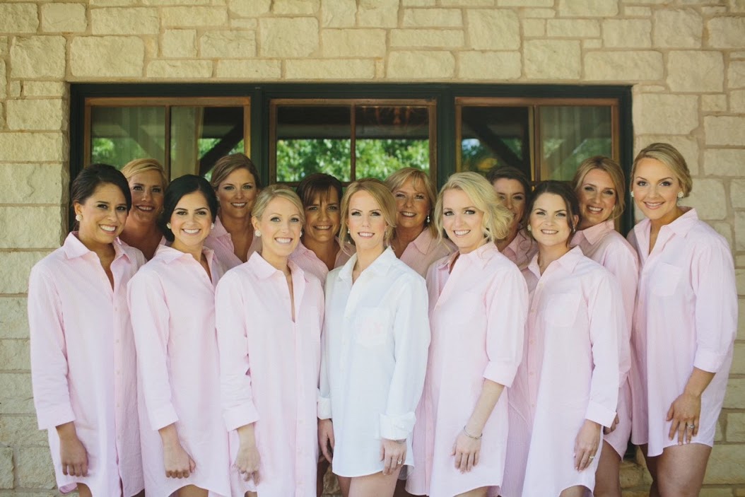 bride surrounded by twelve bridesmaids wearing pink shirts